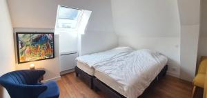 ein kleines Schlafzimmer mit einem Bett und einem Stuhl in der Unterkunft Maison de Ville Ty Art in Quiberon + 9 Fotos