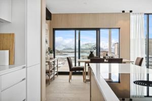 a kitchen and dining room with a view of the ocean at Lyngvær Tide Lodge - No 13 in Storøya