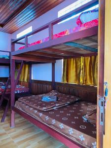 a bedroom with two bunk beds with a bed in it at Cardamom Community Center in Moăt Preăh