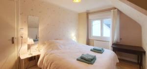 a bedroom with a bed with two towels on it at Maison Ty Plage in Quiberon