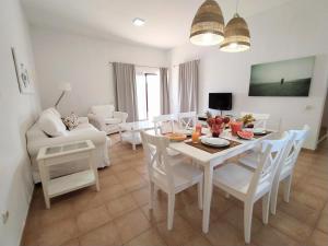 a living room with a white dining room table and chairs at Villa Dunas Fuerteventura in Lajares
