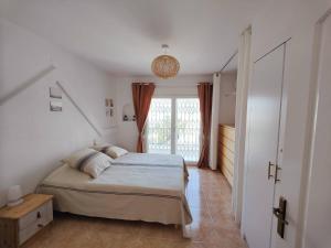 une chambre avec un lit et une grande fenêtre dans l'établissement Casa con vistas al mar y a la montaña en la Almadrava AV-36, à Roses