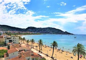 une vue sur une plage avec des palmiers et l'océan dans l'établissement Casa con vistas al mar y a la montaña en la Almadrava AV-36, à Roses