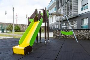 a playground with a green and yellow slide at Rooftop Terrace Apartment PDL in Ponta Delgada