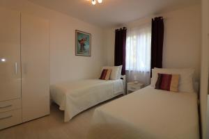 a bedroom with two beds and a window at Ferienhaus - Bungalow Lavanda 2 in Poreč