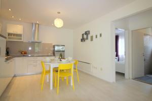 a kitchen and dining room with a table and yellow chairs at Ferienhaus - Bungalow Lavanda 2 in Poreč