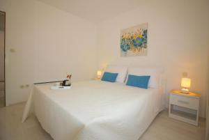 a bedroom with a large white bed with blue pillows at Ferienhaus - Bungalow Lavanda 2 in Poreč +15 photos