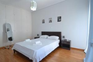 um quarto com uma grande cama branca e uma mesa de cabeceira em A spacious minimal apatment at Chalandri em Atenas