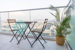 Una mesa de cristal y dos sillas en un balcón. en Bloomfields Stu In Carson, en Dubai Marina