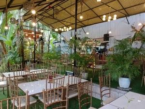 a restaurant with tables and chairs and potted plants at Ecostay Panglao Resort Hotel in Panglao Island