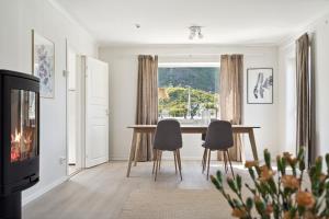 a dining room with a table and chairs and a window at Valen House, Reine in Reine