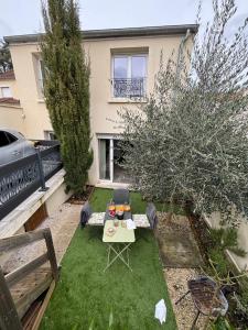 a garden with a table and chairs in front of a house at L Olivier in Nanterre +12 photos