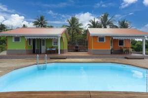 a house and a swimming pool in front of a house at 2 Bungalows avec Piscine in Sainte-Marie