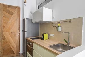 a kitchen with a sink and a wooden door at Le Botanik Jardin Bohème in Fort-de-France