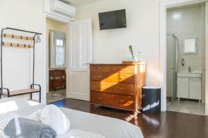 a bedroom with a dresser and a television on a wall at Quinta São José da Relva in Ponta Delgada +39 photos