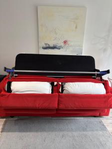 a red bed with two pillows in a room at L Olivier in Nanterre
