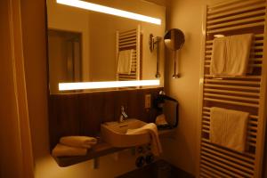 a bathroom with a sink and a mirror and towels at Meyn's Apartments in Soltau