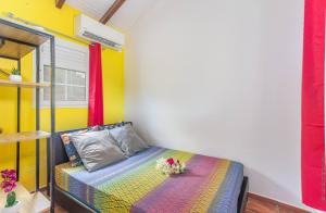 a small bedroom with a bed with flowers on it at Bungalow avec piscine au cœur de la campagne Vert in Sainte-Marie +35 photos