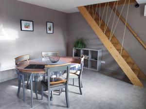 a dining room with a table and a staircase at La maison vigneronne in Polignac