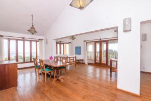 a dining room with a table and chairs and windows at PAVILLION Hill PALACE in Malindi