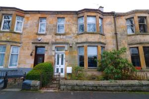 an old stone house with a white door at Signature - St James House in Abbotsinch