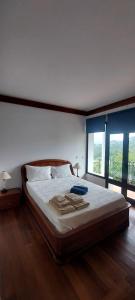 a bedroom with a large bed with two windows at Casa Martagão do Gerês by Gerês Casas in Caniçada +49 photos