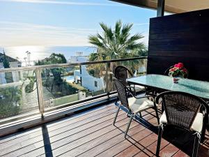 Un patio con una mesa y sillas en un balcón. en Topfloor apartment with terrace and sea views, en Sotogrande