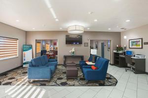 a waiting room with two blue chairs and a desk at Comfort Suites Lewisville - Dallas in Lewisville