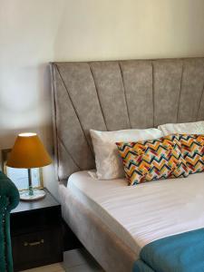 a bed with a headboard and a lamp on a table at bamburi studio in Mombasa