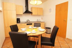 eine Küche mit einem Holztisch und Stühlen in der Unterkunft "Haus Stefanie" Bungalow -1- in Dahme