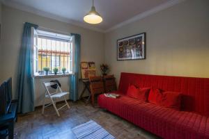 a living room with a red couch and a window at Cascais Boutique Apartment in Cascais