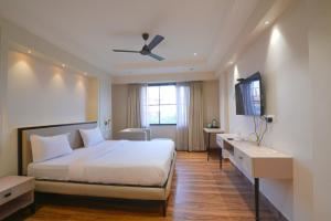 a bedroom with a white bed and a window at Hotel Square 36 in Kota