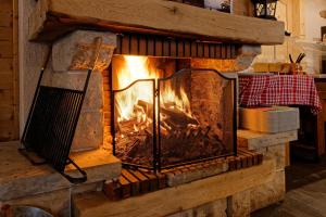 a brick fireplace with a fire in it at L'Auberge au Bord du Lac in Gérardmer