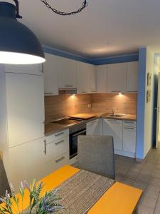 a kitchen with white cabinets and a table and chairs at Seestraße 70, Ap 30 in Zingst