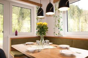 a dining room table with a vase of flowers on it at Ferienwohnung zur Kundler Klamm by FeWo-Plan WILD010 in Dorf