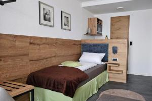 a bedroom with a bed with a wooden headboard at Gasthof Alte Schule in Fürstenzell