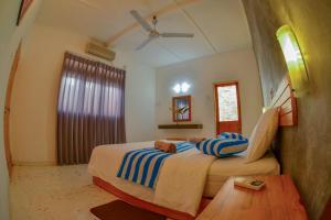 a bedroom with a large bed with blue and white stripes at Villa Raffaello in Galle +20 photos