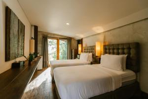 a bedroom with two beds and a large window at The Farmhouse at Polo Escape in Ban Pong
