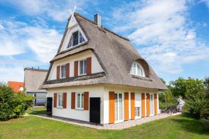 a house with a thatched roof at C 6 Reethaus Strandkorb mit Außenwhirlpool und Sauna in Gramkow