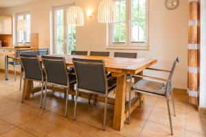a dining room with a wooden table and chairs at C 6 Reethaus Strandkorb mit Außenwhirlpool und Sauna in Gramkow