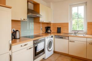 a kitchen with a washing machine and a sink at C 6 Reethaus Strandkorb mit Außenwhirlpool und Sauna in Gramkow +16 photos