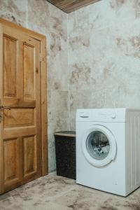 una lavatrice e asciugatrice in una stanza con porta di Luxury Dublex Stone House in Olympos a Kumluca