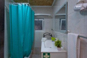 a bathroom with a blue shower curtain and a sink at BeGuest Caparica Cozy Apartment in Costa da Caparica