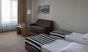 a hotel room with two beds and a chair at Hotel Port 110 in Iława +63 photos