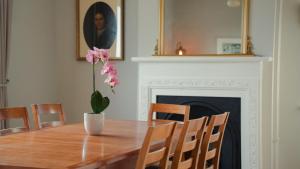 a dining room table with a flower in a vase at Bridge View Cottage in Cawood