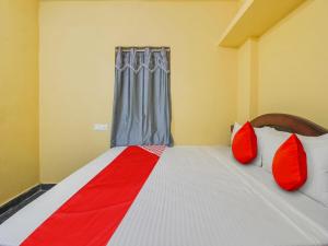 a bedroom with a large bed with red pillows at Hotel O AM Luxury AC ROOM'S in Hyderabad +22 photos