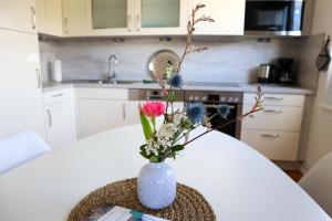 Un jarrón con flores sobre una mesa en una cocina. en Ferienhaus Ostseeliebe, en Dahme 7 fotos más