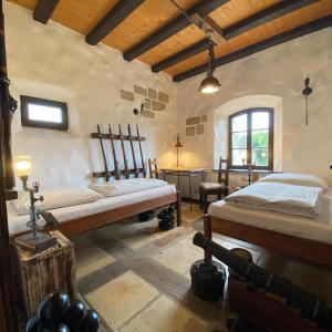 a bedroom with two beds and a table in it at Ferienhaus WAFFENKAMMER für 7 Erw im Rittergut Leppersdorf bei Radeberg in Wachau