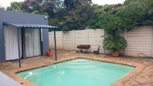 ein kleiner Pool in einem Garten mit einem Zaun in der Unterkunft 329 on 30th Avenue Villieria Jimmy in Pretoria