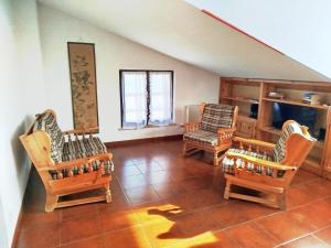 a living room with three chairs and a television at Villa Carla - Lago in Mezzolago